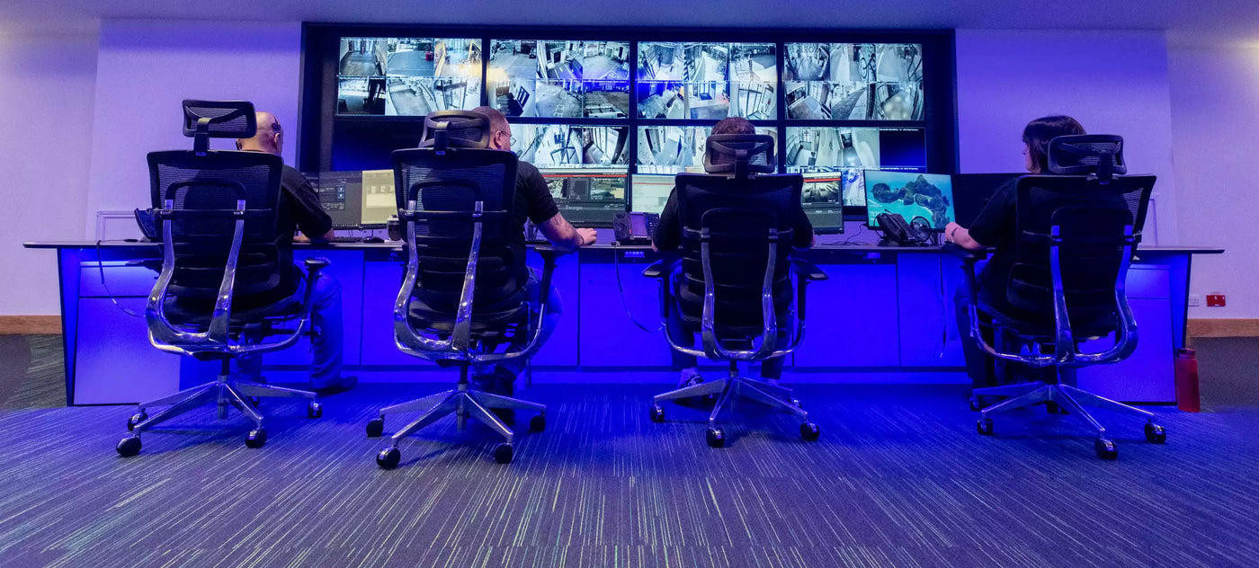 CCTV remote monitoring. 4 people watching large cctv screen