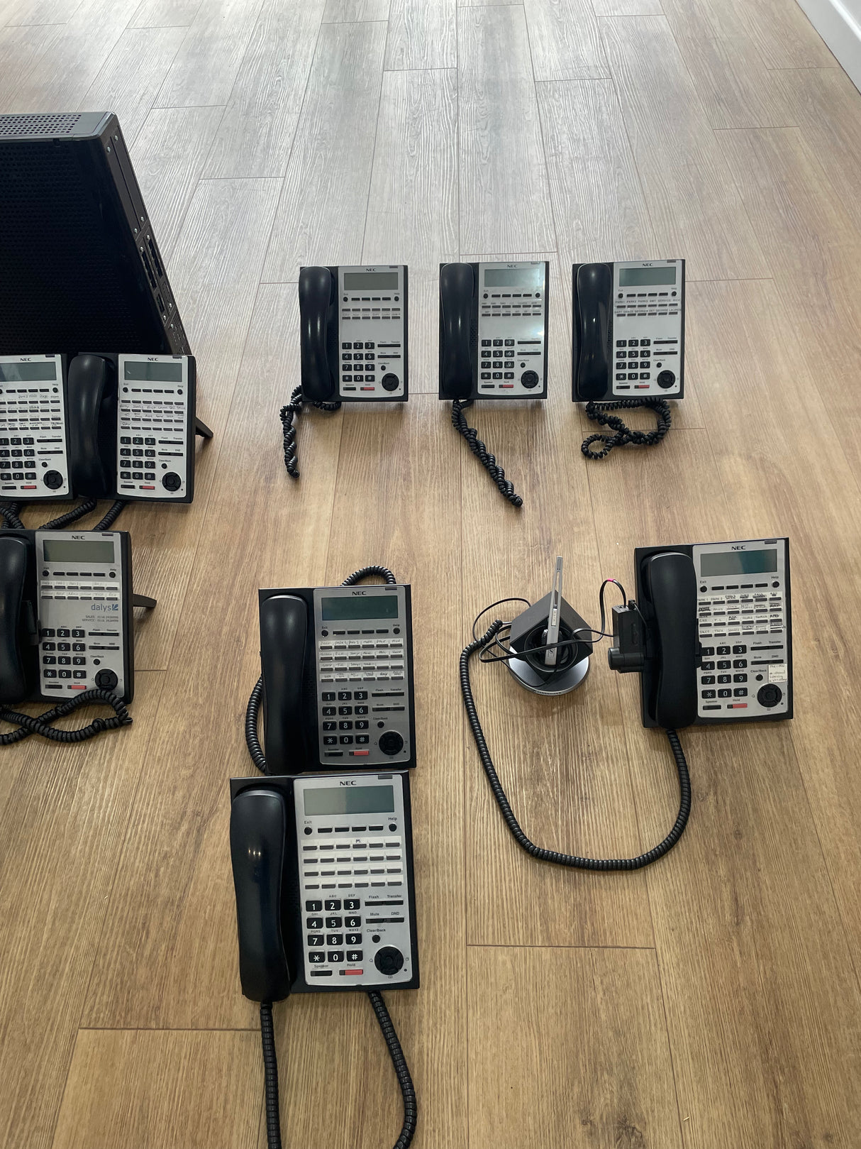 Multiple office phones arranged on a wooden floor