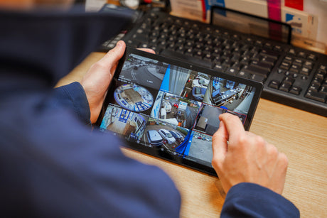 Person looking at MES Systems CCTV camera footage on a Tablet