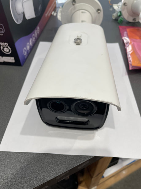 White security camera on a gray surface with a blurred background