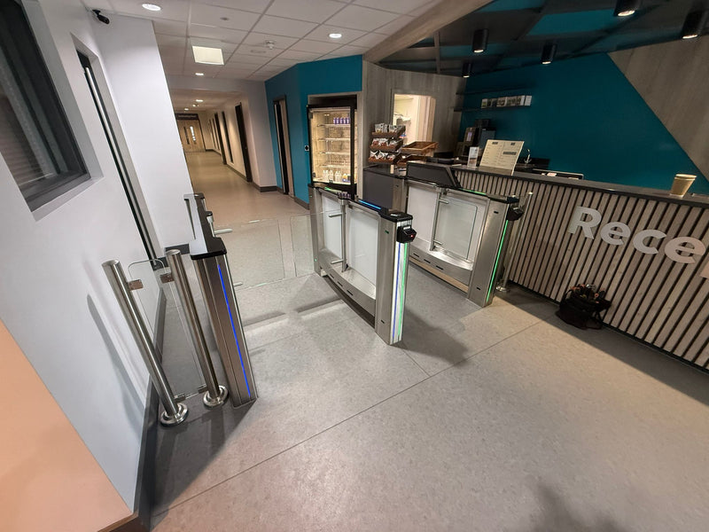 Modern interior of a building with security turnstiles and a reception desk and Came Speed Gate installation at a leisure centre
