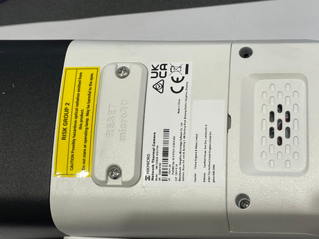 Close-up of a device with labels and certification marks on a dark background