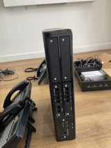 Black electronic device on a wooden desk with office equipment in the background